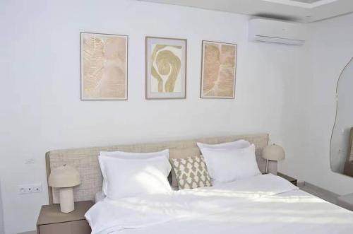 a bedroom with a bed with three pictures on the wall at F3 ngor virage in Dakar