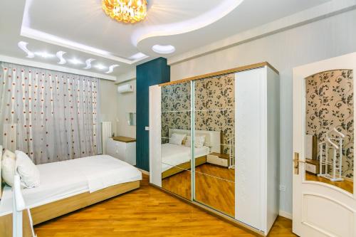 a small bedroom with a bed and a glass closet at Kolorit Modern Apartment in Baku