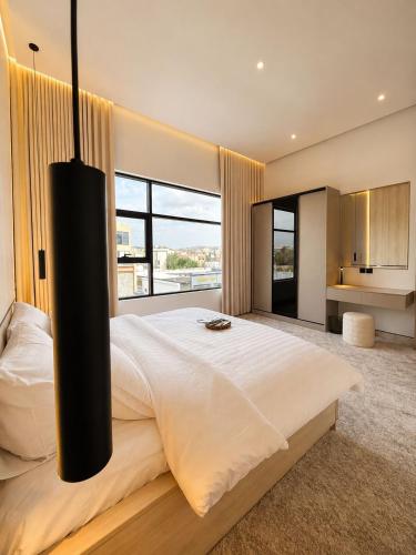 a bedroom with a large bed with a large window at مساكن لينا الفندقية in Abha