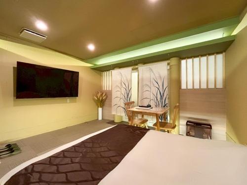 a room with a flat screen tv and a table at HOTEL 壮-soh-shibuya in Tokyo