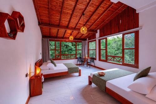 a bedroom with two beds in a room with windows at Hotel Termales Espiritu Santo in Nariño