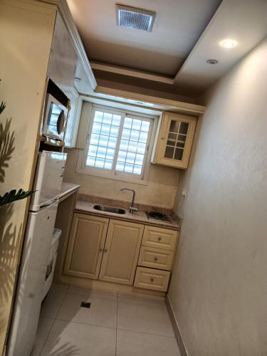 a small kitchen with a sink and a window at شقق فندقيه in Buraydah