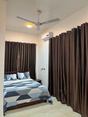 a bedroom with a bed and a ceiling fan at Serene Coastal Escapes GH in Prampram