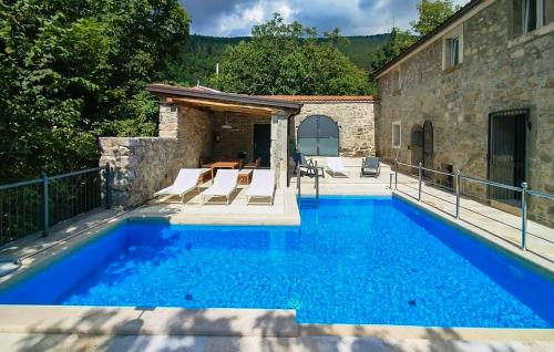 a swimming pool in front of a house at Amazing Home In Lanisce in Lanišće