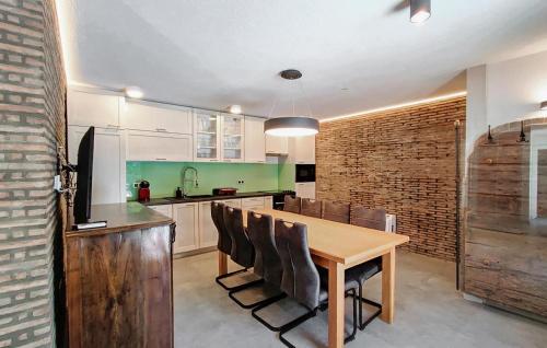 a kitchen with a wooden table and chairs at Amazing Home In Lanisce in Lanišće