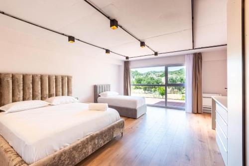 a bedroom with a large bed and a large window at AMA'S Duplex 5 - Parking, Kitchen, Central in Himare