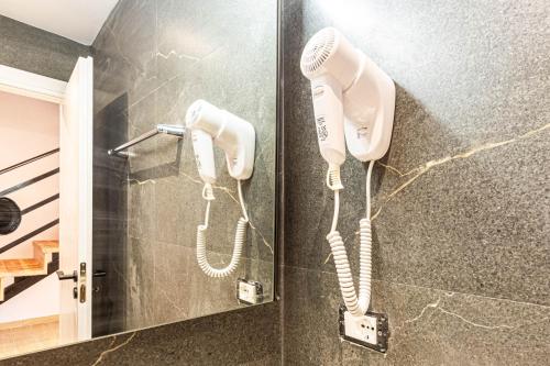 two white phones hanging on a wall in a bathroom at AMA'S Duplex 5 - Parking, Kitchen, Central in Himare