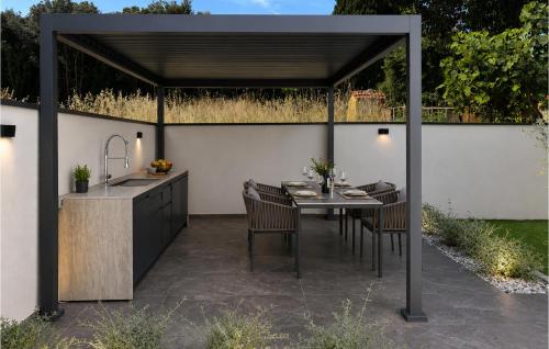 a patio with a table and a kitchen with a sink at Lovely Apartment In Rovinj in Rovinj