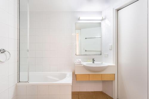 a white bathroom with a tub and a sink at Ocean View Villa in Yeppoon