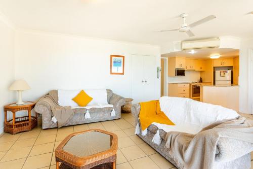 a living room with two couches and a kitchen at Ocean View Villa in Yeppoon