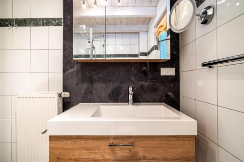a bathroom with a white sink and a mirror at Ferienhaus Kathi - Ihre Auszeit direkt am See in Jabel in Jabel