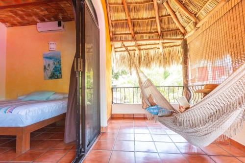 a hammock in a room with a bed and a balcony at Casa Carmela in Sayulita