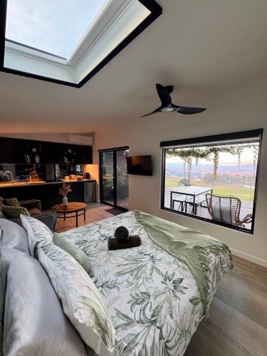 ein Schlafzimmer mit einem großen Bett und einem großen Fenster in der Unterkunft Bluestone Ridge in Whitfield