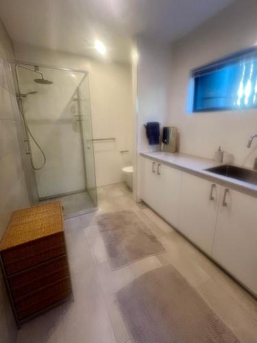 a bathroom with a glass shower and a sink at Your SHACK by the water in Sorell