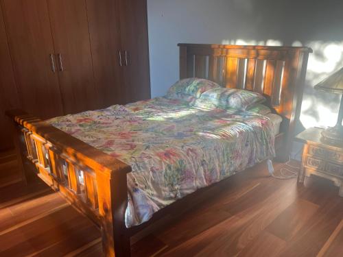 a bed in a bedroom with a wooden bed frame at Your SHACK by the water in Sorell