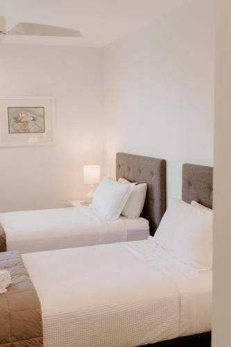 two beds sitting next to each other in a room at Dune View Accommodation in Mangawhai