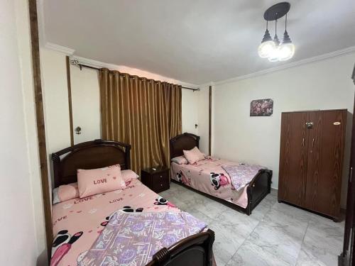a bedroom with two beds in a room at شالية غرفتين بقرية ديمورا in Dawwār Muḩammad Abū Shunaynah