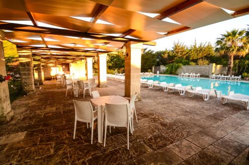 d'une terrasse avec des tables et des chaises à côté de la piscine. dans l'établissement Tenuta Santicuti, à Acaya