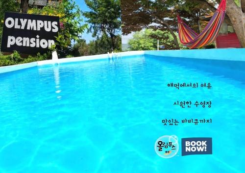 a pool of blue water with a sign on it at Hoengseong Olympus Pension in Hoengseong