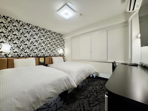 a hotel room with two beds and a desk at APA Hotel Saitama Ageo-Ekimae in Ageo