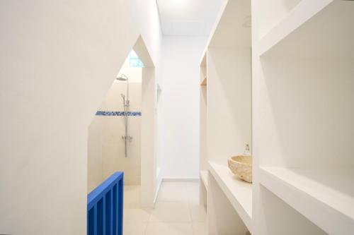 a white bathroom with a shower and a sink at NEW! 3BR Ocean View, Infinity Pool, Villa Helios in Sampalan