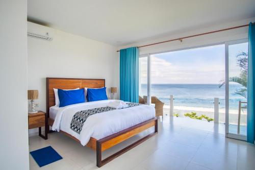 a bedroom with a bed and a view of the ocean at NEW! 3BR Ocean View, Infinity Pool, Villa Helios in Sampalan