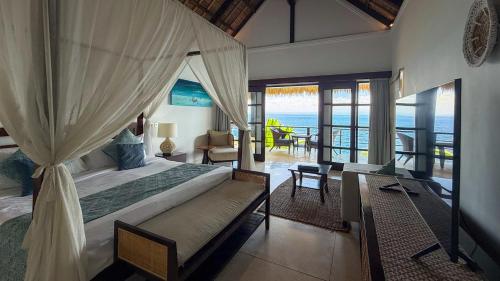 a bedroom with a bed and a view of the ocean at The Point Resort Lembongan in Nusa Lembongan