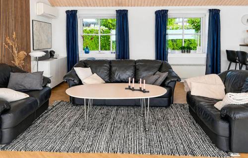 a living room with a leather couch and a table at 2 Bedroom Amazing Home In Faaborg in Faaborg