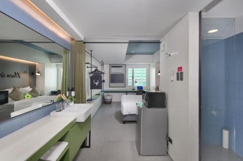 a hospital bathroom with two sinks and a bed at lyf Malate Manila managed by The Ascott Limited in Manila