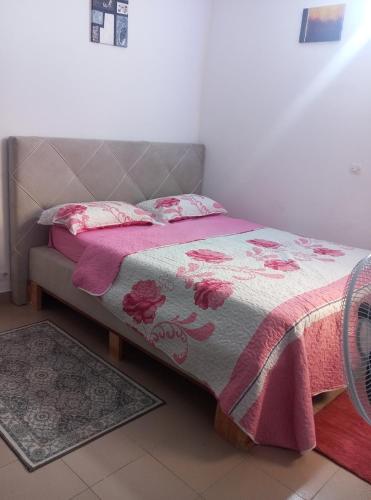 a bedroom with a bed with a pink and gray blanket at Résidence cosy in Abidjan