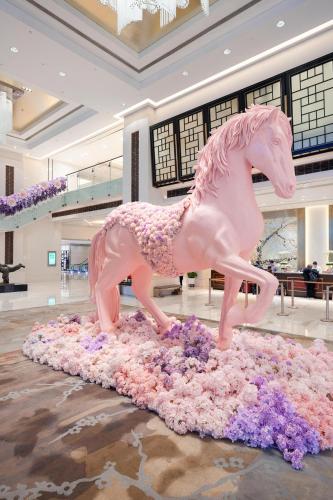a pink horse statue sitting on a pile of flowers at Shangri-La Nanjing in Nanjing