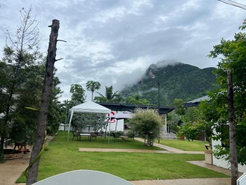 a house with a picnic table and a mountain at พิงภู ไทรโยค in Ban Lum Sum (1)