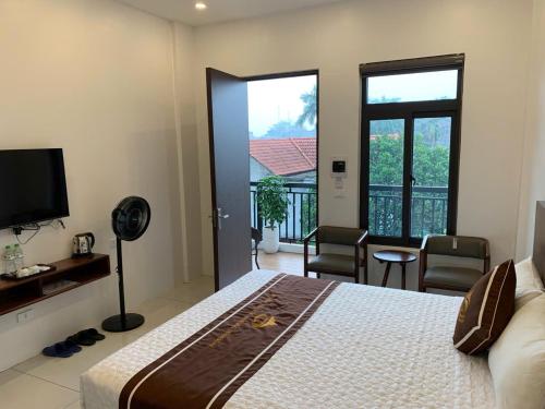 a hotel room with a bed and a balcony at Tam Coc Morning Homestay & Spa Ninh Binh in Vũ Lâm