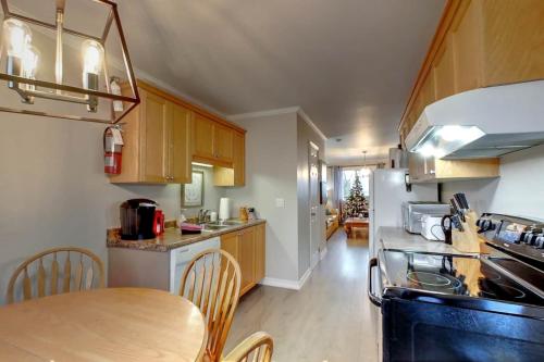 a kitchen with wooden cabinets and a table with chairs at Wasaga Daze - Unit A in Wasaga Beach