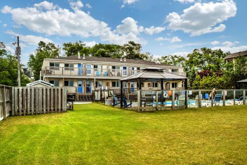 a large house with a fence and a yard at Wasaga Daze - Unit A in Wasaga Beach