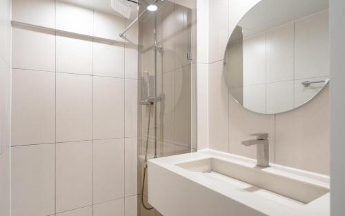 a white bathroom with a sink and a mirror at MH Hotel 3 - Junghwasan in Jeonju