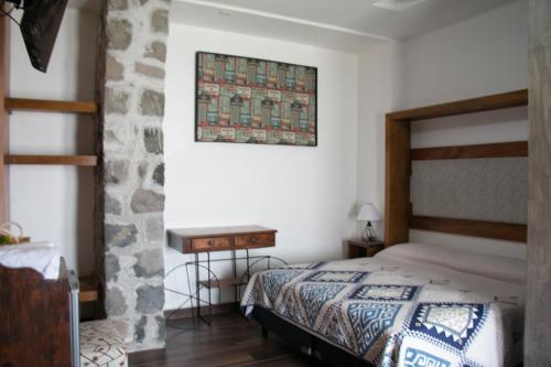a bedroom with a bed and a table on the wall at Ex Hacienda Santa Elena in Atlixco
