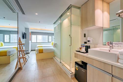 a bathroom with a sink and a mirror at The Mini Suites Eton Tower Makati in Manila