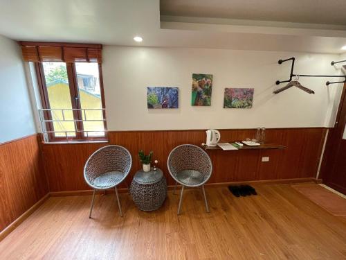 a room with two chairs and a table and a window at Flaco Hostel and Booking Office in Sapa