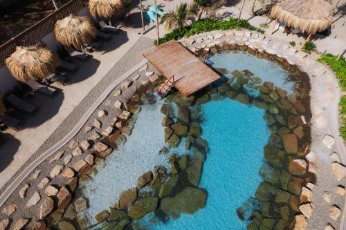 an overhead view of a swimming pool in a resort at ÓRGANOS BEACH bungalows & suites in Los Órganos