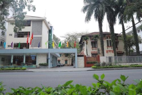 a building with flags in front of a street at Nhà Khách TW in Hanoi
