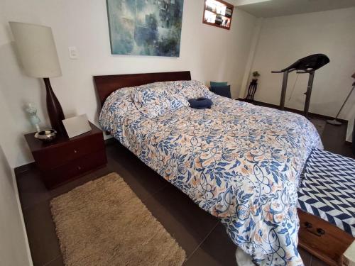 a bedroom with a bed with a blue and white comforter at Casa campestre VALLE ESCONDIDO in Cómbita