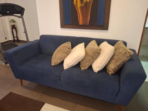 a blue couch with four pillows on it at Casa campestre VALLE ESCONDIDO in Cómbita