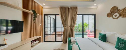 a bedroom with a bed and a large window at Sampai Villa Queensland in Pakem