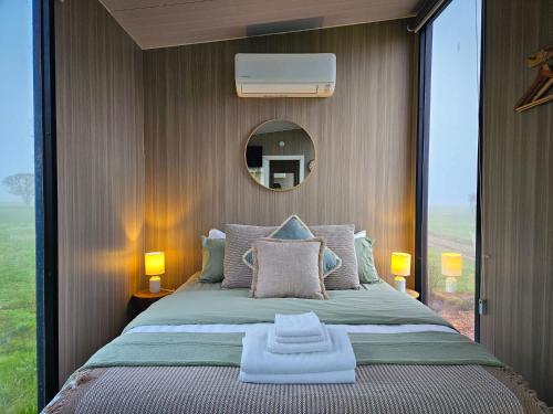 a bedroom with a large bed with a large window at Bec's Place by Tiny Away in Fosterville