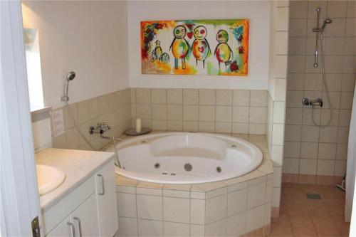 a bathroom with a tub and a shower and a sink at FY296-Faaborg-Mosegarden-27 in Faaborg