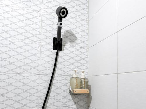 a shower in a bathroom with two bottles on the wall at Eslem GuestHouse in Canggu