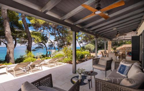 an outdoor patio with chairs and a ceiling fan at Villa Ana in Jelsa