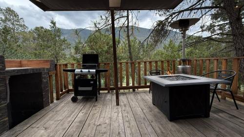 a grill on a deck with a view of the mountains at Glamping MORET Tiny House M1 in Los Lirios