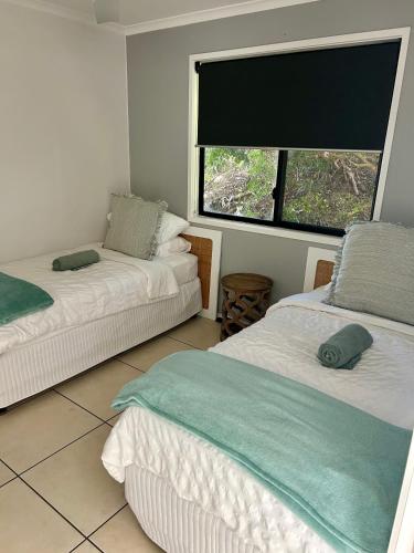 a bedroom with two beds and a large window at Hinterland Ocean Vista Escape in Maroochy River
